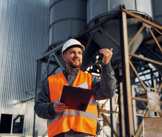 Arbeiter vor Kugelregenanlage Bauerarbeiter in Uniform ist draußen in der Nähe der Kugelregenanlage